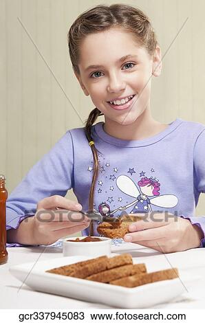 Girl applying jam on the bread View Large Photo Image Stock Image - Girl applying jam on the bread. Fotosearch