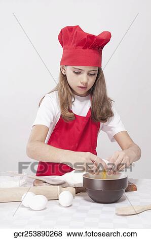 Stock Photo - Girl breaking eggs in a bowl. Fotosearch