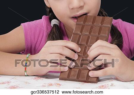 Girl eating a bar of chocolate View Large Photo Image Stock Image - Girl eating a bar of chocolate. Fotosearch