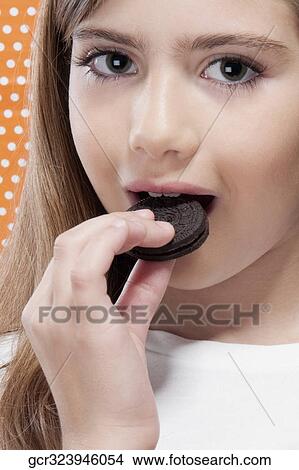 Girl eating a cookie View Large Photo Image Picture - Girl eating a cookie. Fotosearch