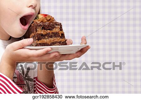 Girl eating a slice of chocolate pastry View Large Photo Image Stock Image - Girl eating a slice of chocolate pastry. Fotosearch