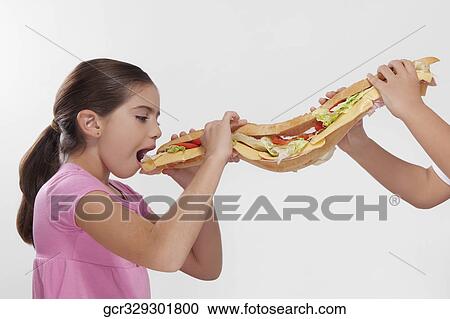 Girl eating a submarine sandwich View Large Photo Image Stock Image - Girl eating a submarine sandwich. Fotosearch