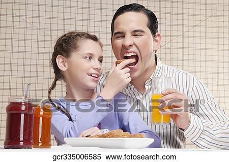 Girl feeding bread to her father View Large Photo Image Stock Photography - Girl feeding bread to her father. Fotosearch