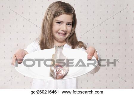 Girl frowning to see a raw fish View Large Photo Image Stock Image - Girl frowning to see a raw fish. Fotosearch