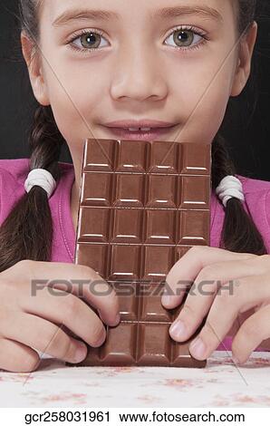 Girl holding a bar of chocolate View Large Photo Image Stock Image - Girl holding a bar of chocolate. Fotosearch