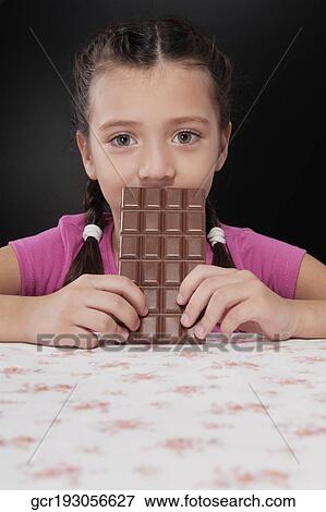 Girl holding a bar of chocolate View Large Photo Image Stock Photo - Girl holding a bar of chocolate. Fotosearch