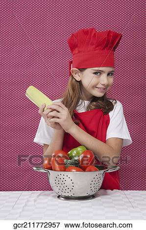Girl holding a corn cob with a colander full of raw vegetables View Large Photo Image Stock Photo - Girl holding a corn cob with a colander full of raw vegetables. Fotosearch