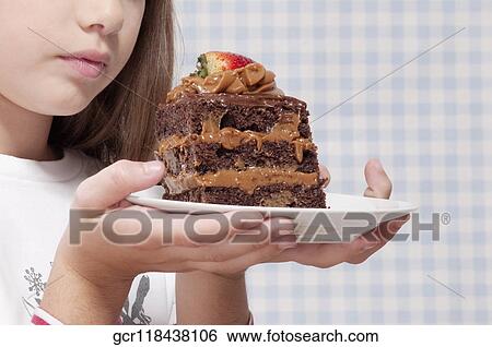 Stock Photograph - Girl holding a plate of chocolate pastry. Fotosearch
