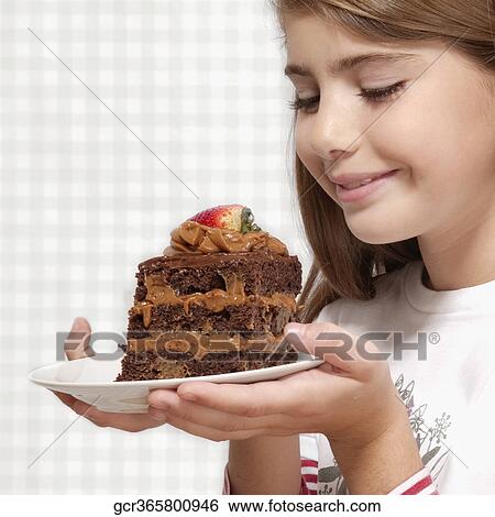 Stock Photograph - Girl holding a plate of chocolate pastry. Fotosearch