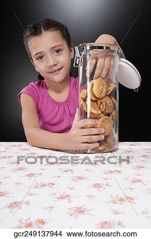 Girl putting her hand into a cookie jar View Large Photo Image Picture - Girl putting her hand into a cookie jar. Fotosearch