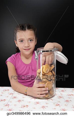 Girl putting her hand into a cookie jar View Large Photo Image Stock Photograph - Girl putting her hand into a cookie jar. Fotosearch