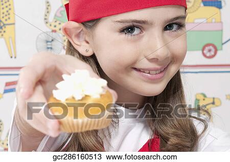 Girl showing a cupcake View Large Photo Image Stock Image - Girl showing a cupcake. Fotosearch