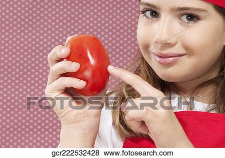 Stock Photo - Girl showing a tomato. Fotosearch