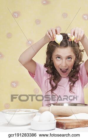 Stock Photograph - Girl spilling egg yolk in a bowl. Fotosearch