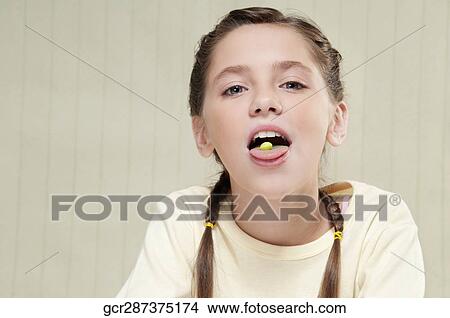 Girl with a candy on her tongue View Large Photo Image Picture - Girl with a candy on her tongue. Fotosearch