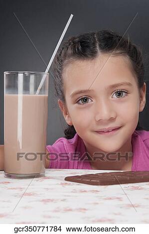Girl with a chocolate bar and a glass of chocolate milkshake View Large Photo Image Picture - Girl with a chocolate bar and a glass of chocolate milkshake. Fotosearch