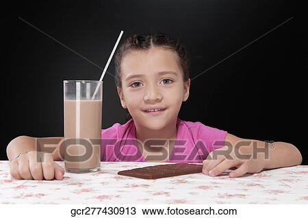 Girl with a chocolate bar and a glass of chocolate milkshake View Large Photo Image Stock Image - Girl with a chocolate bar and a glass of chocolate milkshake. Fotosearch