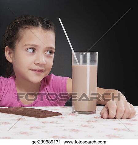 Girl with a chocolate bar and a glass of chocolate milkshake View Large Photo Image Stock Image - Girl with a chocolate bar and a glass of chocolate milkshake. Fotosearch