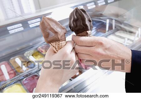 Hands of a couple toasting with ice cream cones View Large Photo Image Stock Photo - Hands of a couple toasting with ice cream cones. Fotosearch