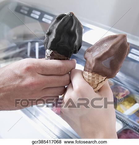 Hands of a couple toasting with ice cream cones View Large Photo Image Stock Photo - Hands of a couple toasting with ice cream cones. Fotosearch