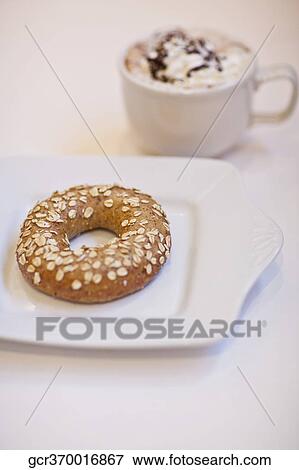 High angle view of a bagel with a cup of coffee View Large Photo Image Stock Photo - High angle view of a bagel with a cup of coffee. Fotosearch