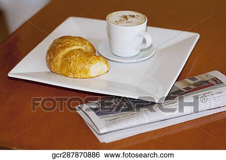 High angle view of a croissant with a cup of coffee View Large Photo Image Stock Photograph - High angle view of a croissant with a cup of coffee. Fotosearch