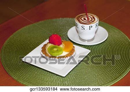 High angle view of a fruit tart with a cup of coffee View Large Photo Image Picture - High angle view of a fruit tart with a cup of coffee. Fotosearch