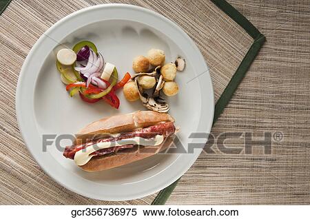 High angle view of a hot dog sandwich served with fritters and salad View Large Photo Image Stock Photography - High angle view of a hot dog sandwich served with fritters and salad. Fotosearch