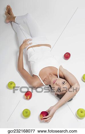 High angle view of a woman lying with red and green apples View Large Photo Image Stock Photo - High angle view of a woman lying with red and green apples. Fotosearch