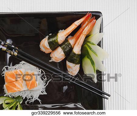 Stock Photograph - High angle view of assorted sushi on a platter with chopsticks. Fotosearch