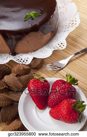 Stock Image - High angle view of chocolate cake and strawberries. Fotosearch