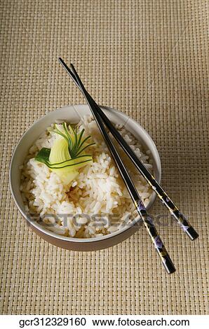 High angle view of chopsticks on a bowl of cooked brown rice View Large Photo Image Stock Image - High angle view of chopsticks on a bowl of cooked brown rice. Fotosearch