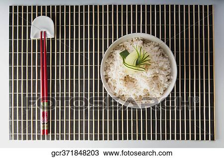 High angle view of chopsticks with a bowl of cooked brown rice View Large Photo Image Stock Image - High angle view of chopsticks with a bowl of cooked brown rice. Fotosearch