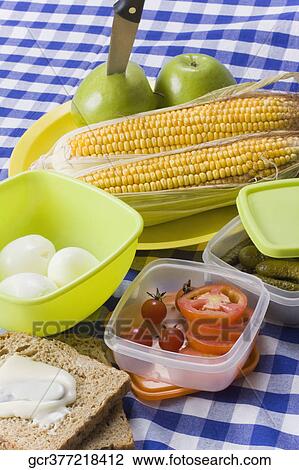 Stock Image - High angle view of cream cheese on a brown bread with fruits and boiled eggs. Fotosearch