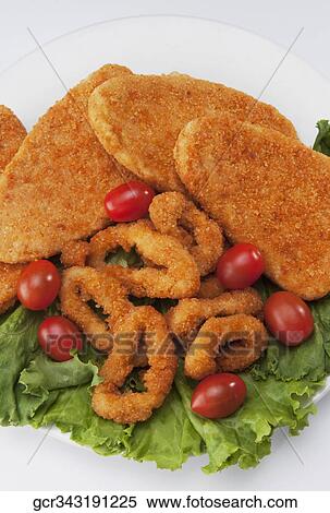 Stock Photography - High angle view of crumb fried onion rings with cutlets. Fotosearch