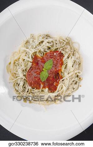 High angle view of fettuccine topped with tomato sauce and basil leaves View Large Photo Image Stock Photograph - High angle view of fettuccine topped with tomato sauce and basil leaves. Fotosearch