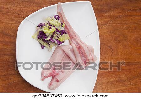 Stock Photo - High angle view of fish slices with red lettuce. Fotosearch
