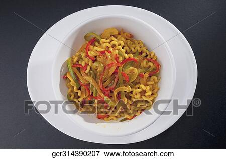 Stock Photo - High angle view of pasta tossed in red and green peppers. Fotosearch