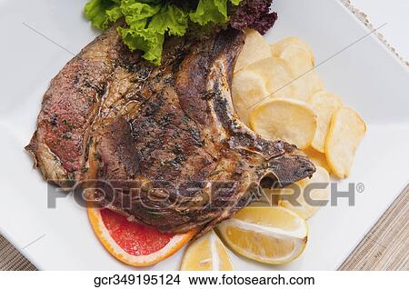 High angle view of pork chops served with fried potatoes View Large Photo Image Picture - High angle view of pork chops served with fried potatoes. Fotosearch