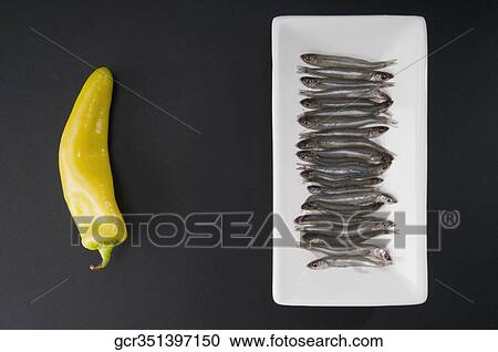 High angle view of sardines and a yellow chili pepper View Large Photo Image Stock Image - High angle view of sardines and a yellow chili pepper. Fotosearch