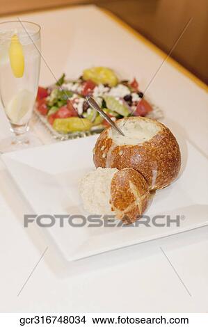 Picture - High angle view of soup served in a bread bowl with salad. Fotosearch