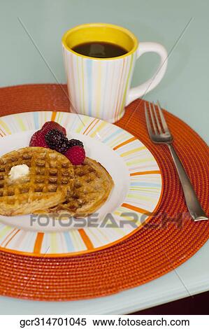 Stock Photography - High angle view of strawberries with waffles and a cup of coffee. Fotosearch