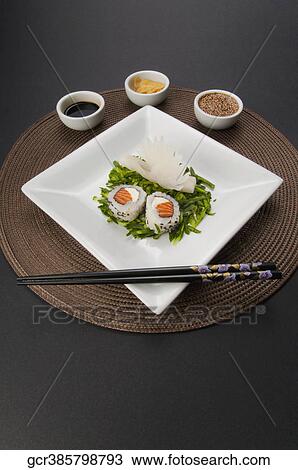 Stock Image - High angle view of sushi rolls served with condiments. Fotosearch