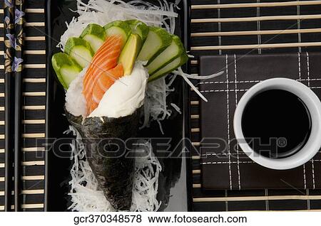 Stock Photo - High angle view of Temaki sushi with soy sauce. Fotosearch