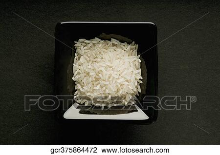 High angle view of uncooked rice in a black bowl View Large Photo Image Stock Image - High angle view of uncooked rice in a black bowl. Fotosearch