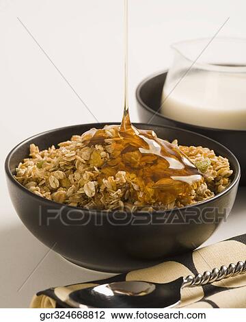 Honey pouring into breakfast cereal with milk View Large Photo Image Stock Image - Honey pouring into breakfast cereal with milk. Fotosearch