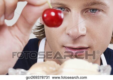 Ice cream seller holding a cherry View Large Photo Image Stock Image - Ice cream seller holding a cherry. Fotosearch