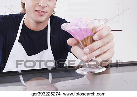 Ice cream seller holding a glass of ice cream View Large Photo Image Picture - Ice cream seller holding a glass of ice cream. Fotosearch