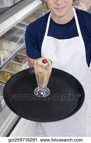 Ice cream seller holding a tray with a glass of ice cream View Large Photo Image Stock Image - Ice cream seller holding a tray with a glass of ice cream. Fotosearch