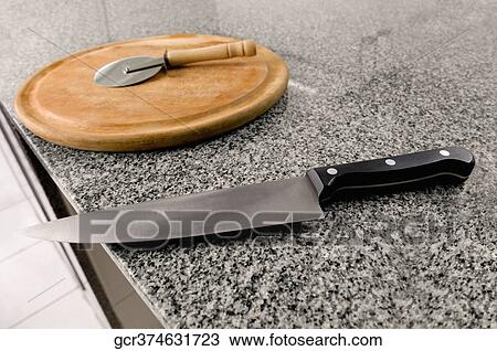 Kitchen knife with a pizza cutter on a cutting board View Large Photo Image Stock Image - Kitchen knife with a pizza cutter on a cutting board. Fotosearch